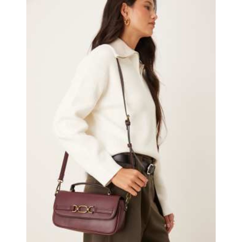Accessorize crossbody bag with gold buckle detailing in burgundy
